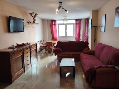 una sala de estar con un sofá y una mesa en House atarfe ii motril, en Atarfe