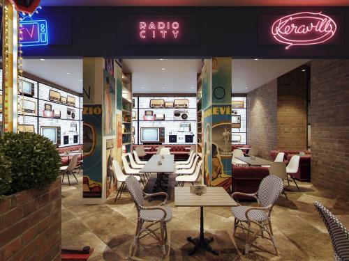 un restaurante con sillas y mesas blancas y un cartel en Mamaison Vibe Hotel Downtown Budapest, en Budapest