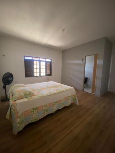 een slaapkamer met een bed en een raam bij Casa imperr in Aracati