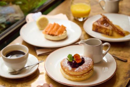 ロンドンにあるThe May Fair, A Radisson Collection Hotel, Mayfair Londonのペストリープレートとコーヒー付きのテーブル