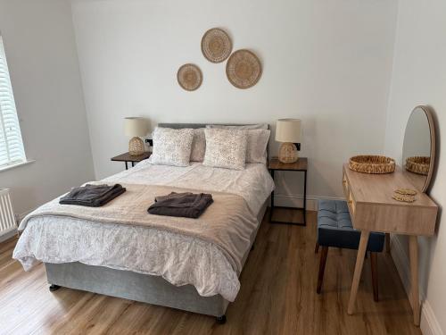 ein Schlafzimmer mit einem Bett, einem Tisch und einem Schreibtisch in der Unterkunft The Old Gatehouse in Legbourne