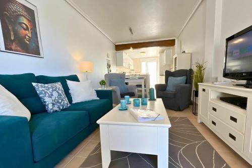 a living room with a blue couch and a tv at Sun golf and swimming pool the ideal villa for your holidays! in Vistabella