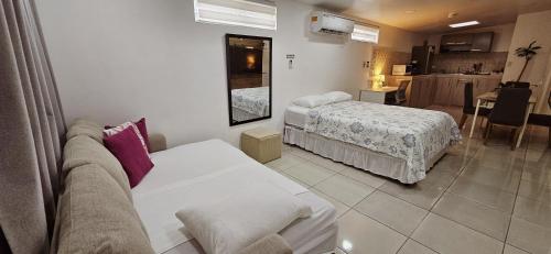 a hotel room with two beds and a kitchen at Tocumen Airport Los Corcho Suites in Tapia Número Dos