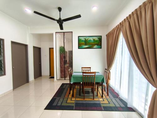 a dining room with a green table and chairs at Ana Homestay Moslim only 4 airconds Wi-Fi in Alor Setar