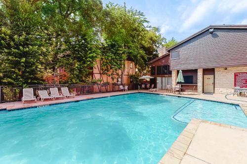 a large swimming pool with chairs and a house at Camp Warnecke Estates Unit B104 in New Braunfels