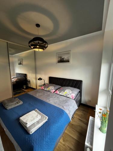 a bedroom with a bed with a blue blanket at Apartament Bajka nad Jeziorem in Nysa