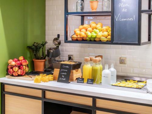un mostrador con comida, bebidas y fruta. en Mercure Avignon TGV Hotel & Spa, en Aviñón