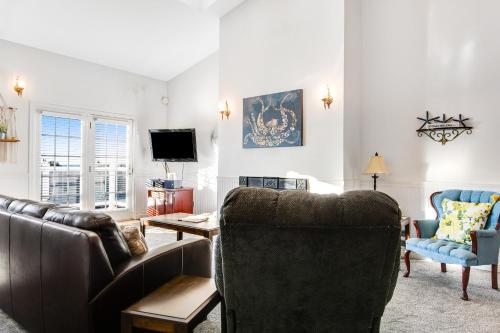 a living room with leather furniture and a tv at The Marietta at Judith Ann Inn in Ocean Shores