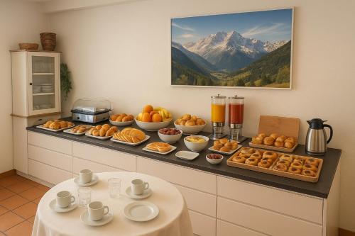 a counter with a bunch of breakfast foods on it at Oberthaler Hotel in Sappada