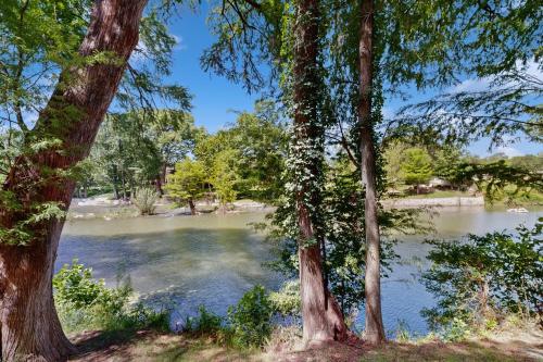 a view of a lake from between two trees at The Village at Gruene in New Braunfels