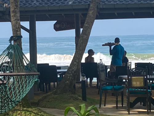 希克杜沃Suite Lanka的一群人坐在海滩的桌子上