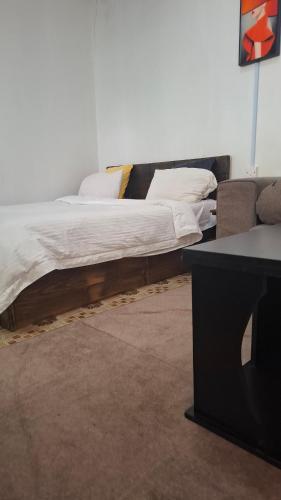 a bed sitting in a room next to a couch at Sinty's furnished homes in Narok