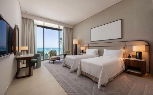 a hotel room with a bed and a view of the ocean at Palace Beach Resort in El Alamein