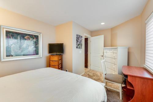 ein Schlafzimmer mit einem Bett, einem Schreibtisch und einem Fernseher in der Unterkunft Lake Chelan Shores Chelan Beauty 18-7 in Lakeside