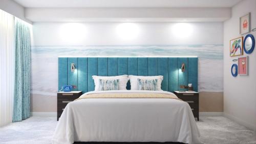 een slaapkamer met een groot bed met een blauw hoofdeinde bij Hotel Indigo Torquay, By IHG in Torquay