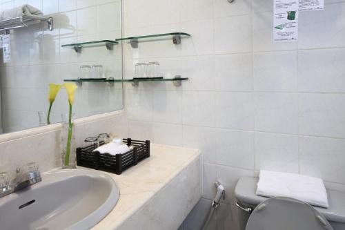 a white bathroom with a sink and a toilet at Manila Lotus Hotel in Manila