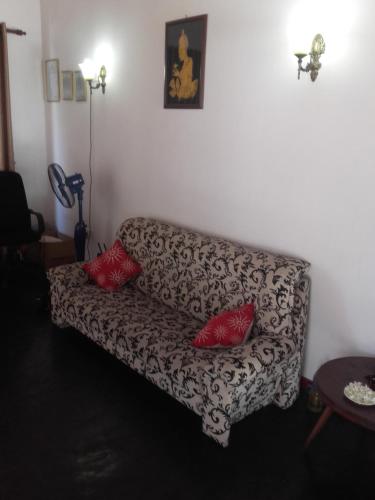 a living room with a couch with two red pillows at The Kingston Hotel in Kiribathgoda
