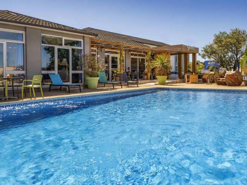 a swimming pool in front of a house at greet Hotel Marseille Provence Aéroport in Vitrolles