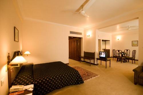 a bedroom with a bed and a living room at Hotel Express Residency-Jamnagar in Sika