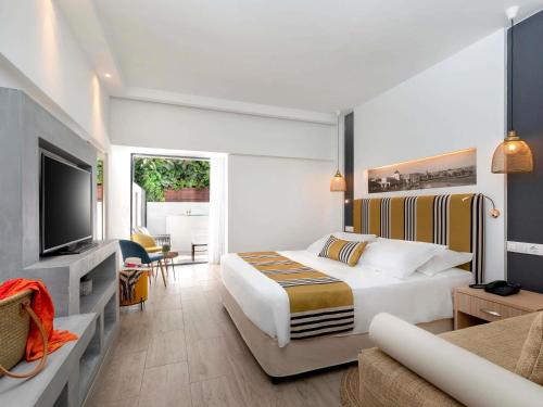 a hotel room with a bed and a television at Mercure Rhodes Alexia Hotel & Spa in Rhodes Town