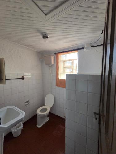 a bathroom with a toilet and a sink at Pousada Recreio Girassol in São Roque
