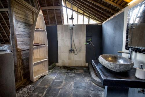 a bathroom with a large sink and a shower at Gipsy Beach Bungalows in Sekotong