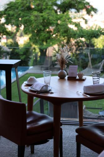 a wooden table with plates and glasses on top of it at Le Clos Des Sens in Annecy
