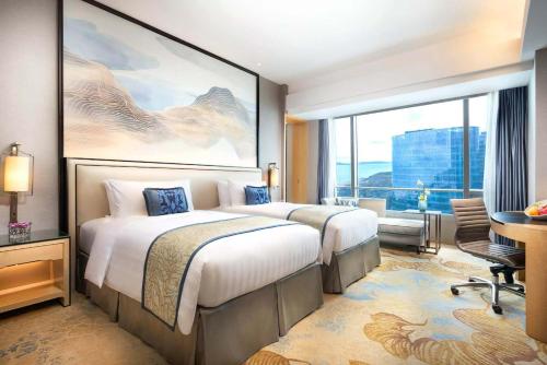 a hotel room with two beds and a large window at Shangri-La Xiamen in Xiamen
