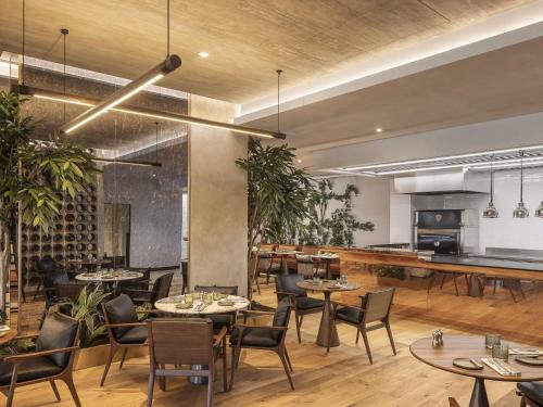 um restaurante com mesas e cadeiras em uma sala em Fairmont Golden Prague em Praga