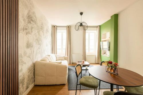 a living room with a table and a couch at Le Goupil in Chalon-sur-Saône