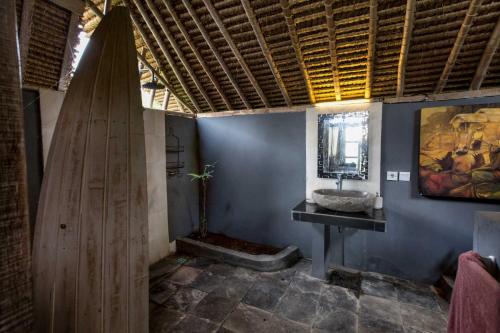 a bathroom with a sink and a surfboard at Gipsy Beach Bungalows in Sekotong