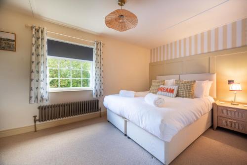 a bedroom with a white bed and a window at Waterhen Cottage in Docking