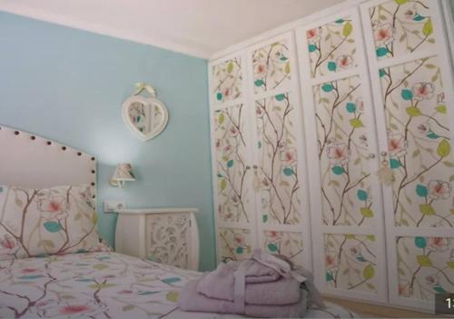a bedroom with a bed with a floral wall at Alojamiento Oasis Playa in Águilas
