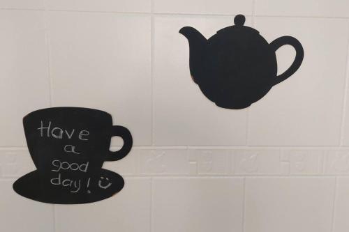 una tazza nera e un cartello con scritto "buona giornata" di Alojamiento Oasis Playa ad Águilas