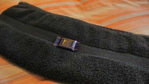 a black sweater with a blue collar on a bed at Chata Rosa in Malenovice