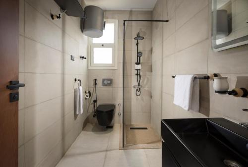 a bathroom with a black toilet and a sink at Rivana Residence New Cairo - Pool & GYM Access in Cairo