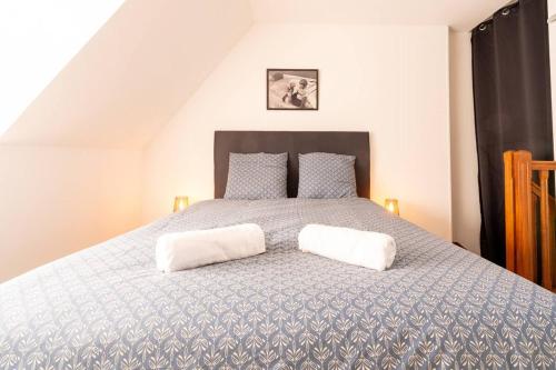 a bedroom with a bed with two white pillows at O Ricoul - Maison avec jacuzzi proche Rennes in Corps-Nuds