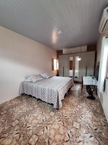 une chambre avec un grand lit dans une pièce dans l'établissement Casa para cop30, à Belém