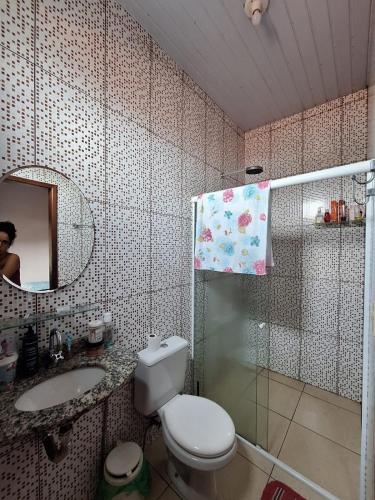 une salle de bain avec toilettes, lavabo et miroir dans l'établissement Casa para cop30, à Belém