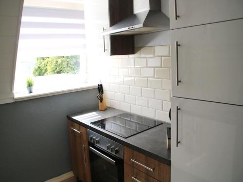 a kitchen with a stove and a sink and a window at Cozy Apartment in Bedburg-Hau in Bedburg Hau