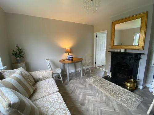 a living room with a couch and a table with a mirror at Katie's Cosy Cottage in Ballyjamesduff