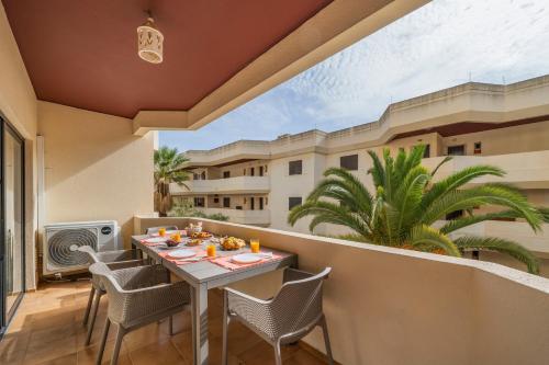 a patio with a table and chairs on a balcony at Sea View & Shared Pool in Lagos by HostWise in Lagos