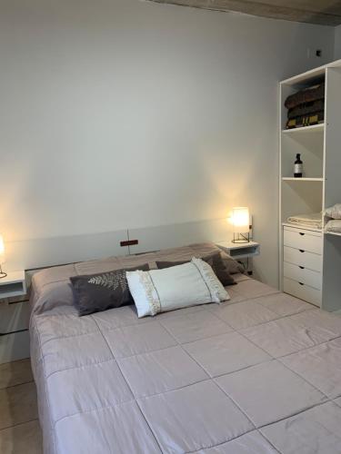 1 dormitorio con 1 cama grande con una cruz en la pared en Casa Monte hermoso a media cuadra Del Mar, en Monte Hermoso