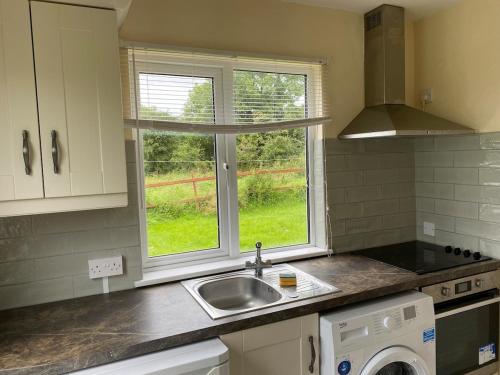 a kitchen with a sink and a window at Katie's Cosy Cottage in Ballyjamesduff
