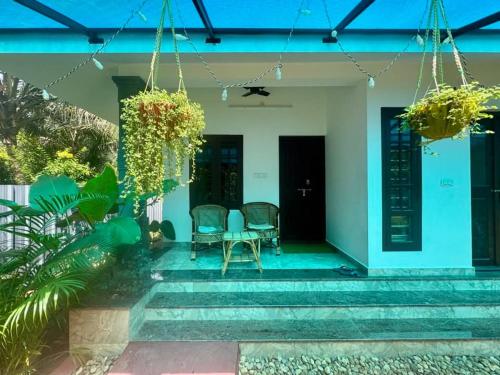 a patio with a table and chairs in a house at Kuttappy dreams in Alleppey