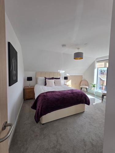 a bedroom with a large bed with a purple blanket at Suite Bowl in Exmouth