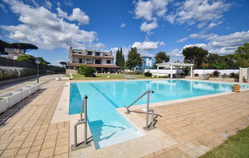 a large swimming pool with a house in the background at Villa Baia Del Circeo in Colonia Elena