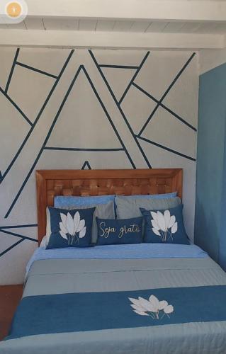 a bedroom with a bed with blue and white pillows at EcoChalé de Arraial in Arraial do Cabo