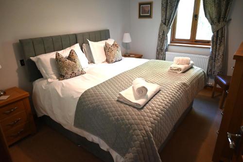 a bedroom with a bed with two towels on it at Heads Nook Hall Cottage in Carlisle