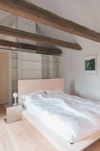 a large white bed in a bedroom with wooden beams at Verwalterinnenhaus in Werben
